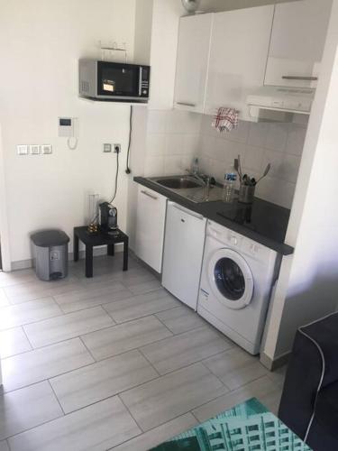a kitchen with a washing machine and a sink at Studio meublé. Proche mer et centre ville in Nice