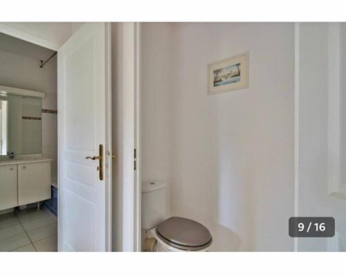 a white bathroom with a toilet and a sink at Grand Noble - Blagnac in Blagnac
