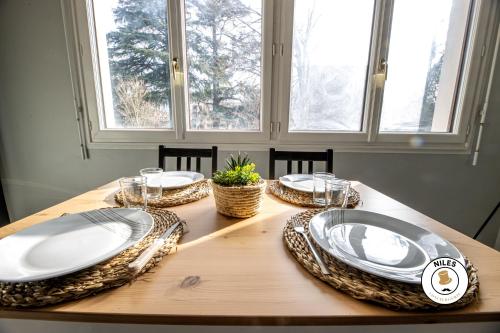 une table en bois avec des assiettes et des verres au-dessus dans l'établissement RARE, Fonctionnel, Idéal Famille ou Business, à Pau