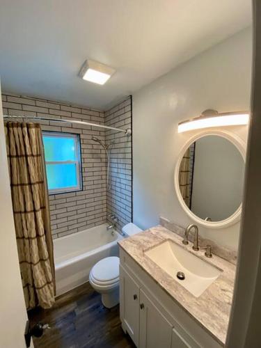 a bathroom with a sink and a toilet and a mirror at Serene and Modern 5 Location, Queen Bed, Parking in Birmingham