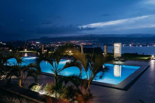 a view of a swimming pool at night at Mantis Kivu Marina Bay Hotel in Muhari