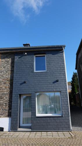 a black brick building with a window at La Tanière des Loups in Herbeumont
