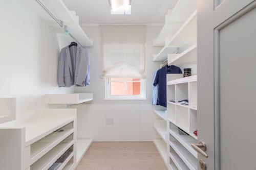 a white walk in closet with white shelves at Villa Laura in Pula
