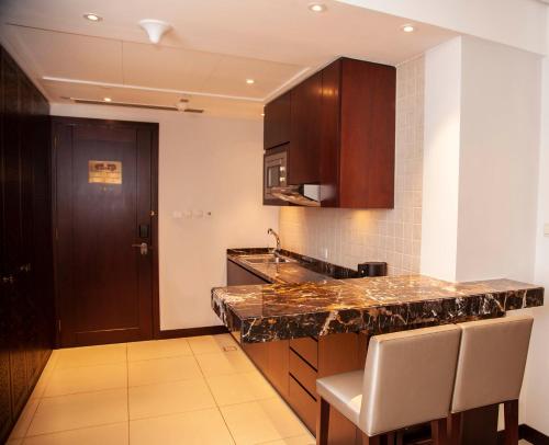 a kitchen with a counter and a sink and a door at Bab Al Qasr Hotel in Abu Dhabi