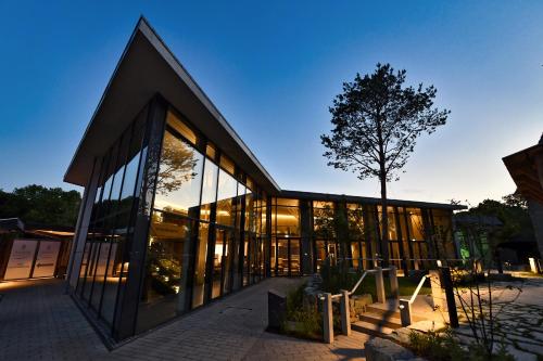 a large glass building with a tree in front of it at Haus Sigge Ferienwohnungen in Bad Sassendorf