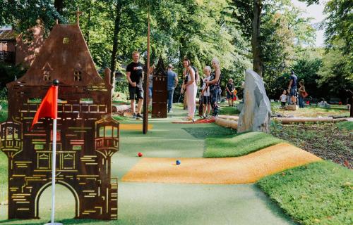 a group of people standing around a miniature golf course at Haus Sigge Ferienwohnungen in Bad Sassendorf