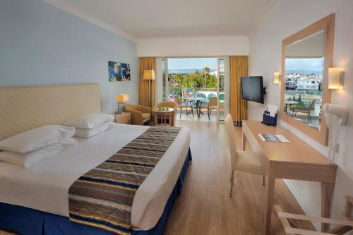 Postel nebo postele na pokoji v ubytování Olympic Lagoon Resort Paphos