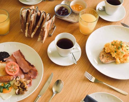 a table with plates of food and a cup of coffee at Balnearn House in Aberfeldy