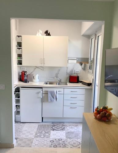 une cuisine blanche avec des armoires blanches et un évier dans l'établissement Studio Mimosa Croisette, à Cannes