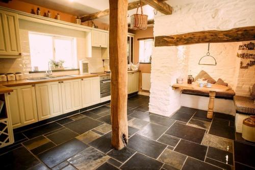 a large kitchen with a table in the middle at Charming Welsh Cottage in Johnston