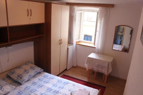 Habitación pequeña con cama y ventana en Apartments Seka Korčula, en Korčula
