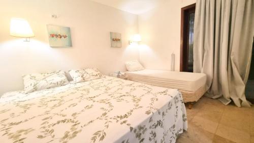 um quarto branco com uma cama e uma janela em Apt no Taiba Beach Resort em Taíba