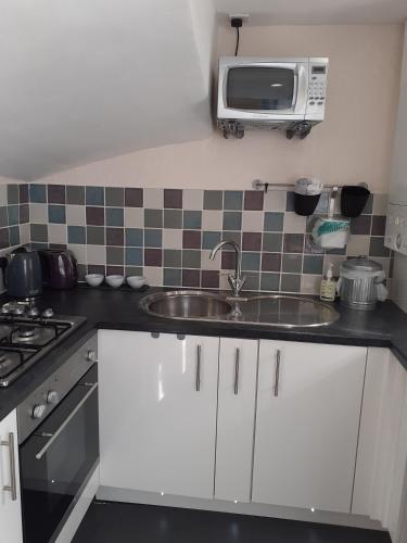 クーパーにあるBees Townhouse- Cuparのシンクと電子レンジ付きのキッチン