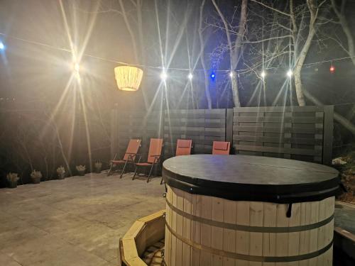 a stage with chairs and a barrel with lights at Illaberek Vendégház in Sukoró