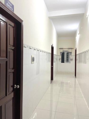an empty hallway with white walls and a door at Nhà Nghĩ Hải Yến in Long Hai