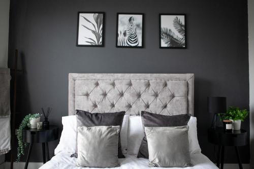 a bedroom with a bed with four pictures on the wall at Modern city centre apartment roof garden in Manchester