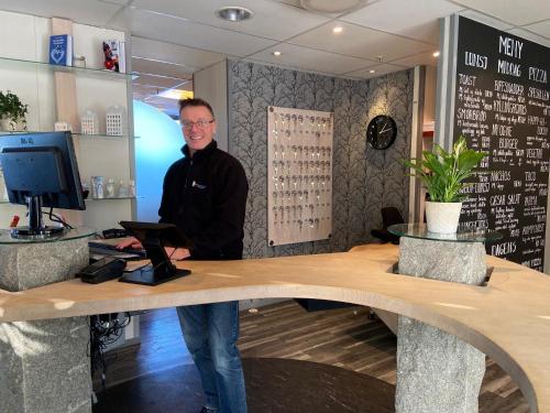 a man standing at a counter in a store at Vikingskipet Hotell in Hamar