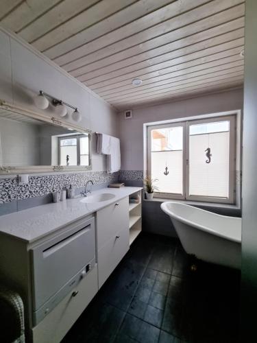a bathroom with a tub and a sink and a bath tub at Villa Marienholm in Haapsalu