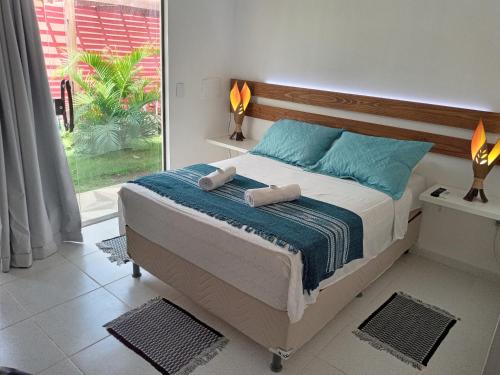 a bedroom with a bed with two towels on it at AYRE GOSTOSO POUSADA in São Miguel do Gostoso