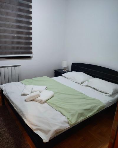 a bedroom with a bed with two towels on it at Zlatiborski Konaci-Apartman Maletic in Zlatibor