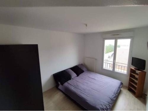 1 dormitorio con cama y ventana en Beau F3 neuf et lumineux proche val europe, disney, en Neufmoutiers-en-Brie