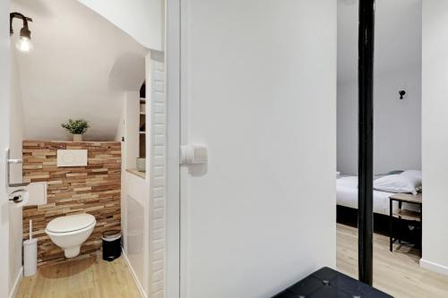 baño pequeño con aseo y cama en Parfait studio pour un accès rapide à la Sorbonne! en París