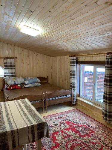 a room with a bed and a large window at Подина in Vorokhta