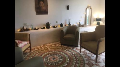 a living room with a table with chairs and a rug at Chez Alice,simplicité et petite piscine in Mirandol-Bourgnounac