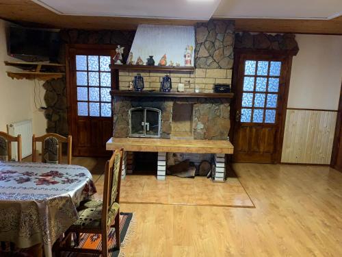 a living room with a stone fireplace and a table at Подина in Vorokhta