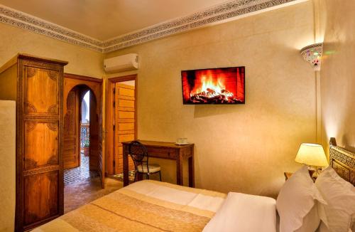 - une chambre avec un lit orné d'une peinture au feu sur le mur dans l'établissement RIAD VILLA SIDI BABA, à Marrakech