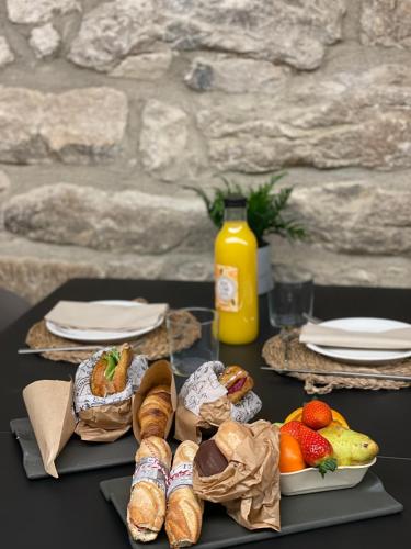 a table with bread and fruit and a bottle of orange juice at Les Quingles in Calders