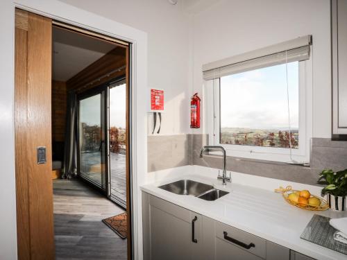 una cucina con un lavandino e una finestra di Hilltop Lodge a Corwen