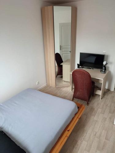 Dormitorio con cama, escritorio y TV en Beau F3 neuf et lumineux proche val europe, disney, en Neufmoutiers-en-Brie