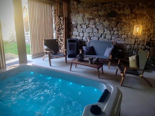 a pool in a living room with a couch and chairs at Au gré du Lot in Le Bourg