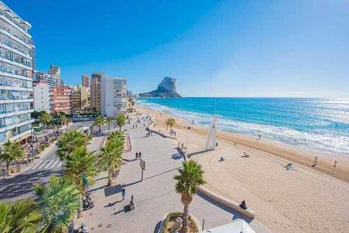 a view of a beach with people and the ocean at Apartamento Capri - PlusHolidays in Calpe