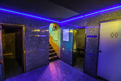 baño con luces púrpuras y escaleras en una habitación en Pensjonat Fitness & Spa Gregor, en Zielona Góra