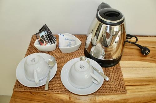 a tea pot and plates on a wooden table at The Kebon Lombok in Kuta Lombok