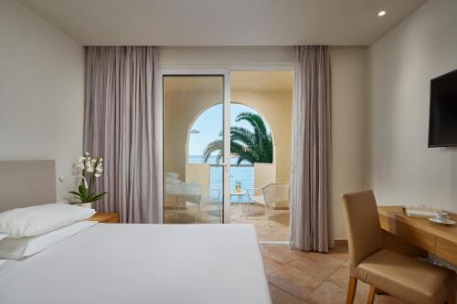 a hotel room with a bed and a desk and a bedroom at Lindos Royal Resort in Lindos