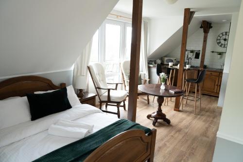 a bedroom with a bed and a table and a kitchen at Noclegi Panorama in Ustrzyki Dolne