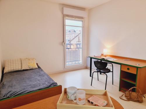 聖艾蒂安的住宿－NEORESID RESIDENCE TREFILERIE，一间卧室配有书桌、一张床、一张桌子和椅子