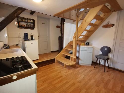 - une cuisine avec un escalier en colimaçon dans une petite pièce dans l'établissement Gîte La Charmaie, à Husseren-Wesserling