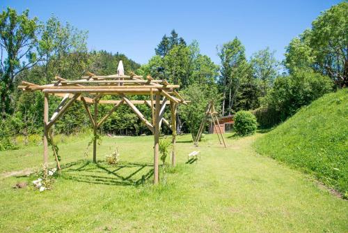 a wooden pergola in the middle of a field at Domaine de Malpas in Villers-le-Lac