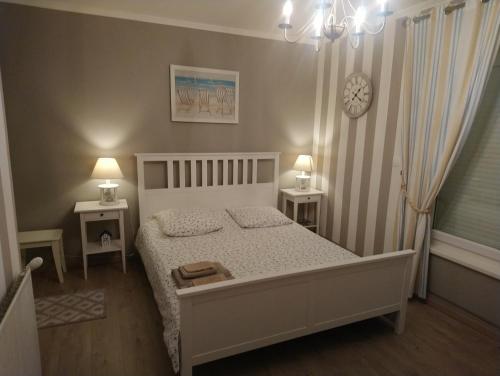 a bedroom with a white bed and two night stands at La Nouvelle Criqueboise in Criquebeuf-en-Caux