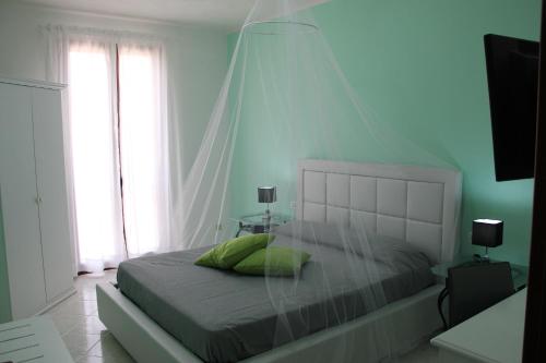 a bedroom with a bed with a mosquito net at B&B Trapani Bedda in Paceco