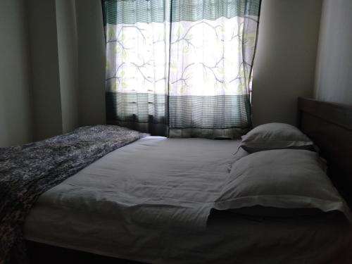 a bed in a room with a window withimov at Hotel Bonolota international in Rājshāhi