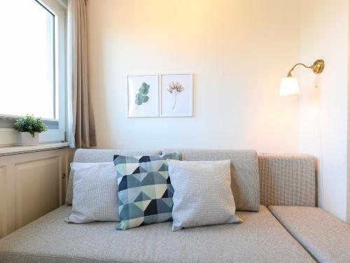 un sofá con almohadas en la sala de estar. en Appartement Kaya, en Westerland