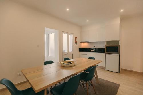 a kitchen and dining room with a wooden table and chairs at Beach House by Azores Villas in São Roque