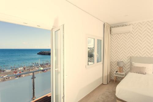 a bedroom with a bed and a view of the ocean at Beach House by Azores Villas in São Roque