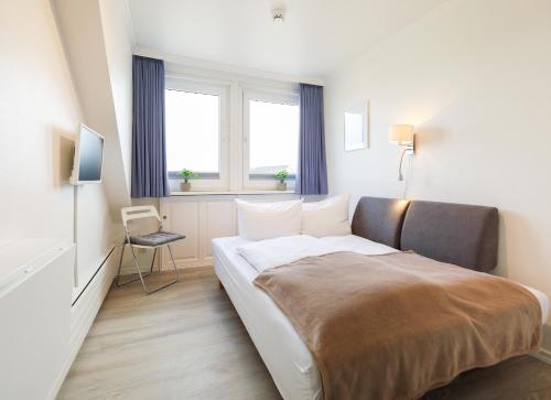 Habitación de hotel con cama y silla en Appartement Jasper, en Westerland
