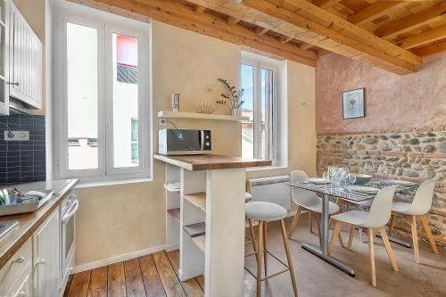 - une cuisine et une salle à manger avec une table et un four micro-ondes dans l'établissement LE CASTELET - Cosy duplex proche du centre-ville, à Toulouse